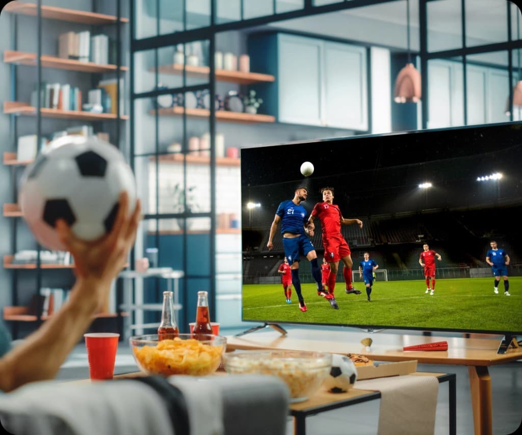 Watching live football on IPTV on a big screen in a modern living room