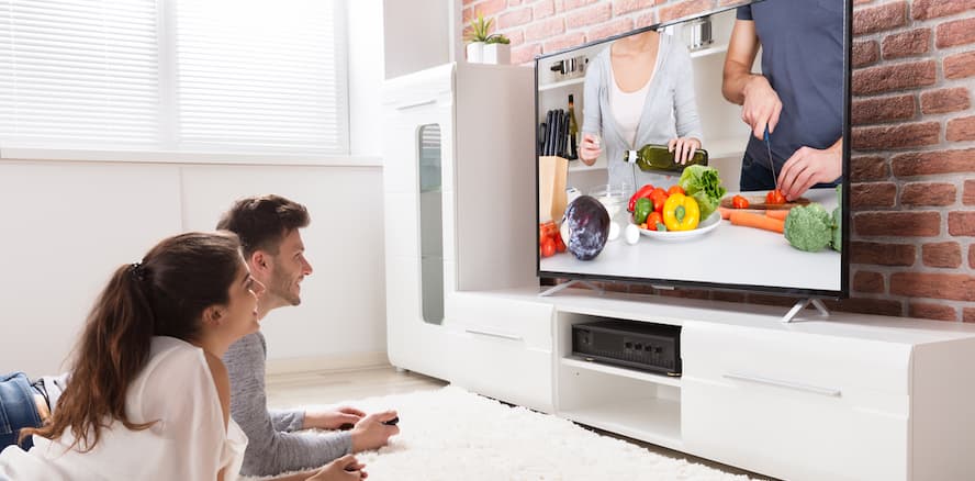 Couple watching TV comfortably at home